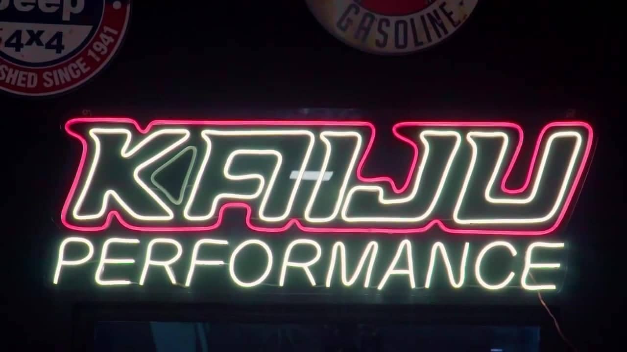 Letreiro neon Kaiju Performance dentro da oficina